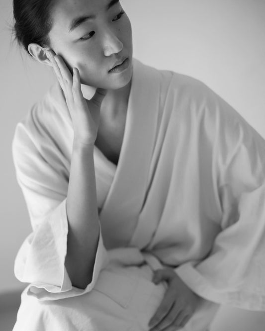Foto Blanco y Negro de una chica sentada con una bata Laguna Cyprien x Takamura