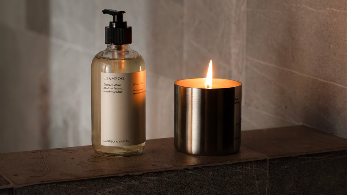 Un jabon liquido dentro de una botella de vidrio estetica ,minimal . Una vela aromatica con aroma a higo